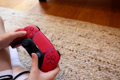 Photo of Child playing video games with controller indoors, closeup. Space for text