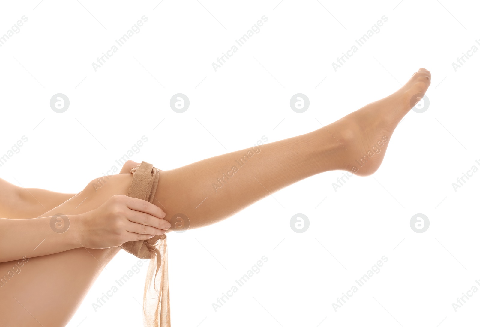 Photo of Young woman putting on tights against white background, closeup