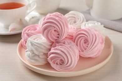 Photo of Plate with delicious pink zephyrs on white table