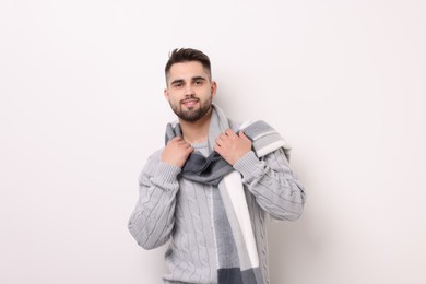 Photo of Portrait of smiling man in warm scarf on light background