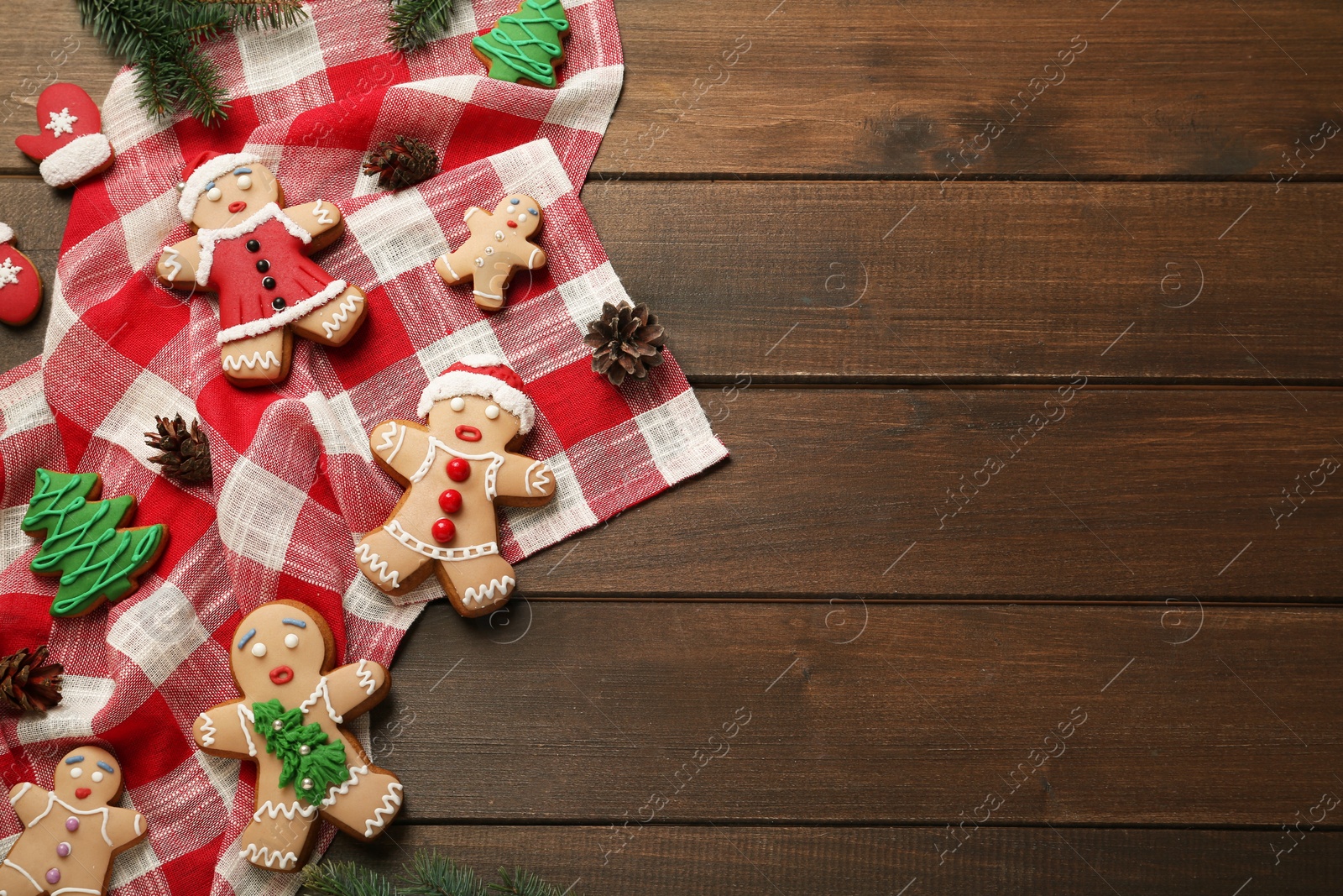 Photo of Delicious Christmas cookies and pine cones on wooden table, flat lay. Space for text