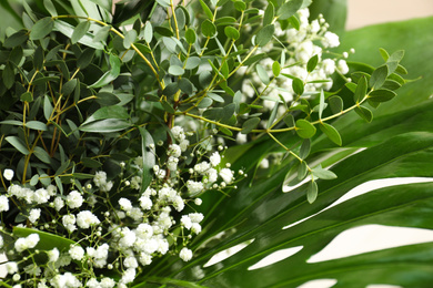 Photo of Beautiful bouquet with white flowers and green leaves, closeup. Floral background