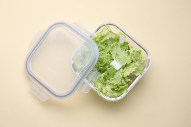 Glass container with fresh cabbage and lid on beige background, top view