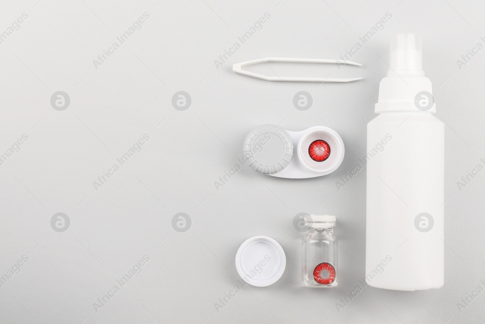 Photo of Flat lay composition with color contact lenses on light grey background, space for text