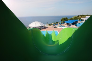 Photo of Green slide in water park on sunny day