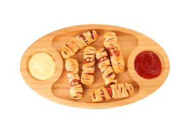 Cute sausage mummies served with sauce isolated on white, top view. Halloween party food
