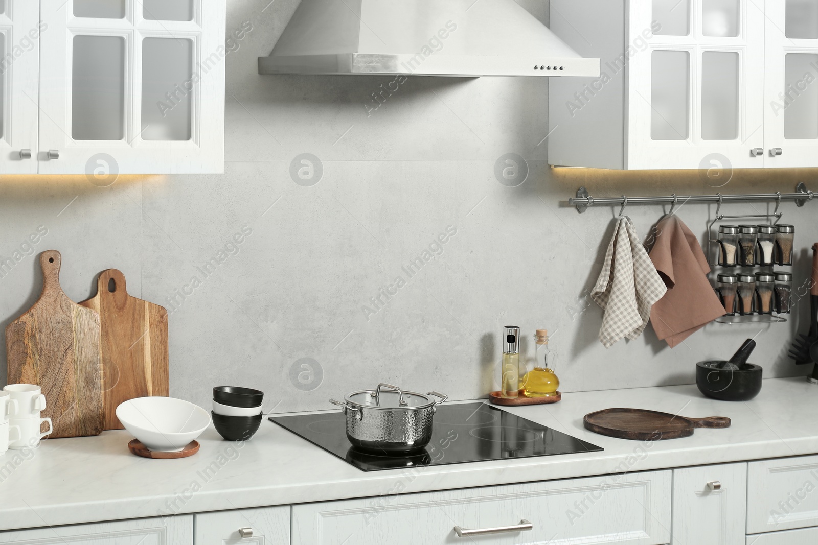 Photo of Wooden cutting boards and other cooking utensils on white countertop in kitchen