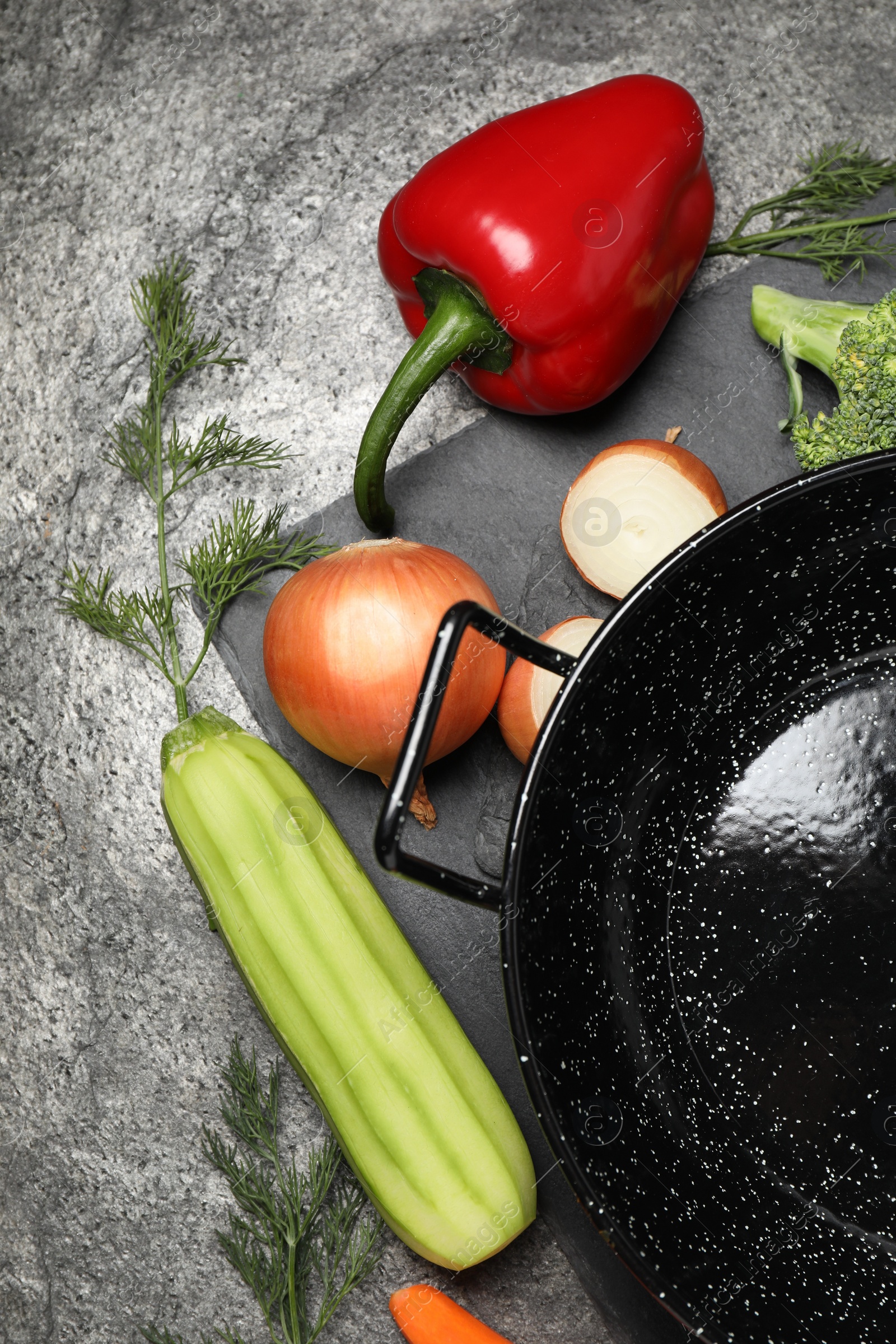 Photo of Empty iron wok and raw ingredients on grey table, flat lay