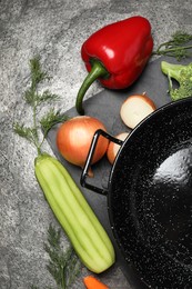 Photo of Empty iron wok and raw ingredients on grey table, flat lay