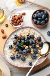 Photo of Flat lay composition with tasty oatmeal porridge and ingredients served on wooden table. Healthy meal