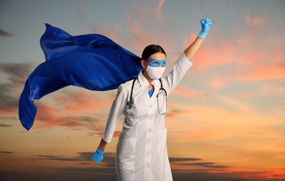 Image of Medical workers fighting with dangerous diseases. Doctor dressed as superhero posing against sky