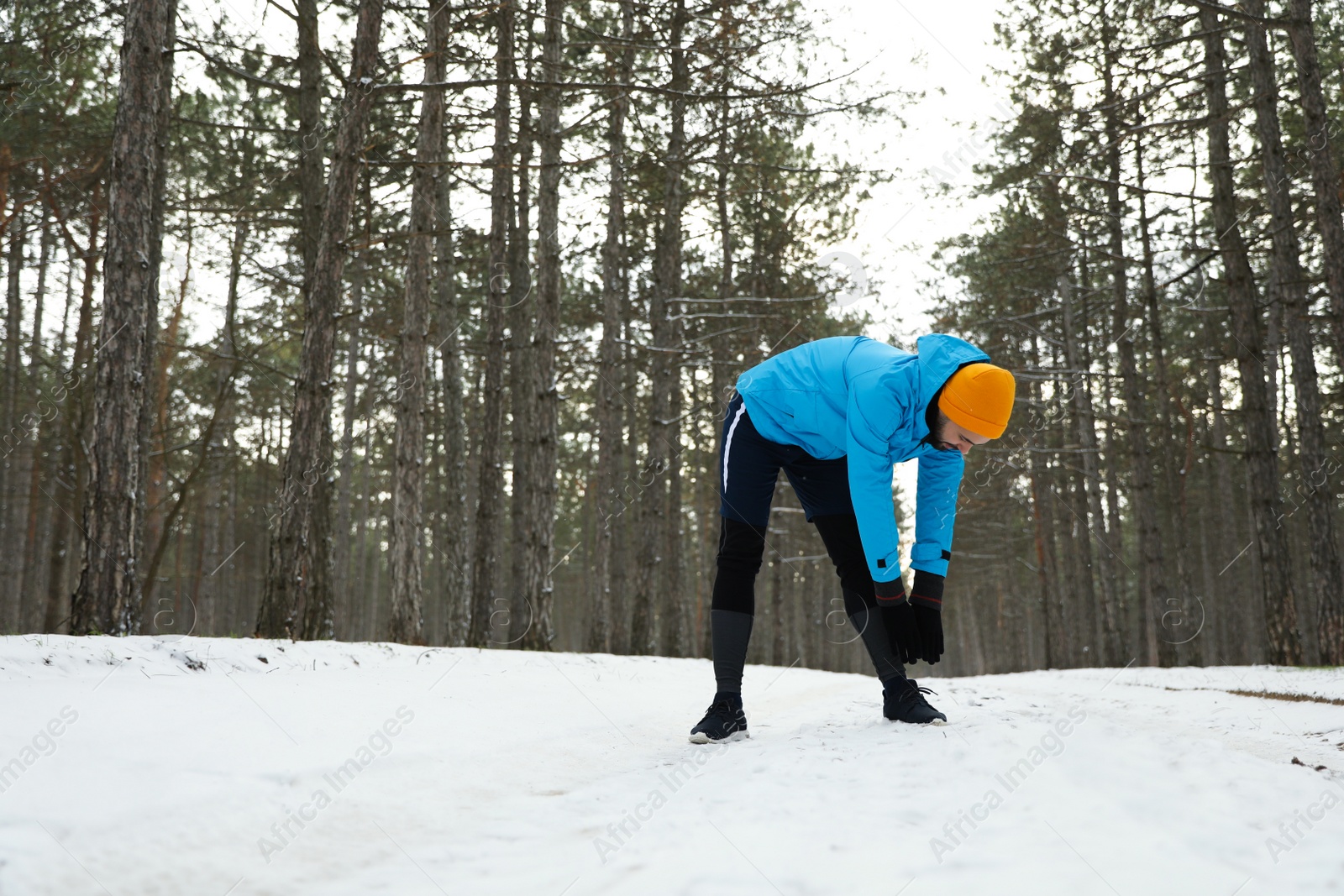 Photo of Man doing sports exercises in winter forest