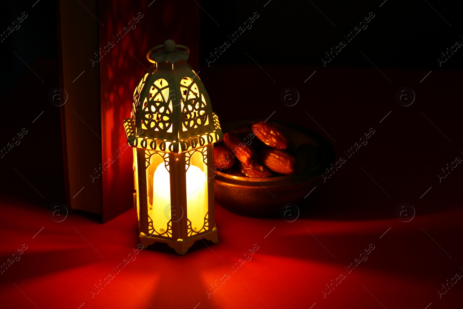 Photo of Decorative Arabic lantern and dates on table against dark background. Space for text