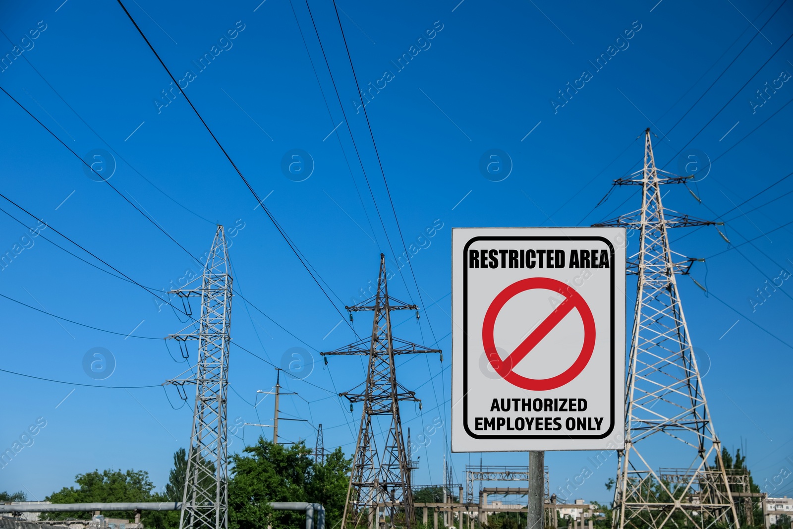 Image of Sign with text Restricted Area Authorized Employees Only near high voltage towers outdoors