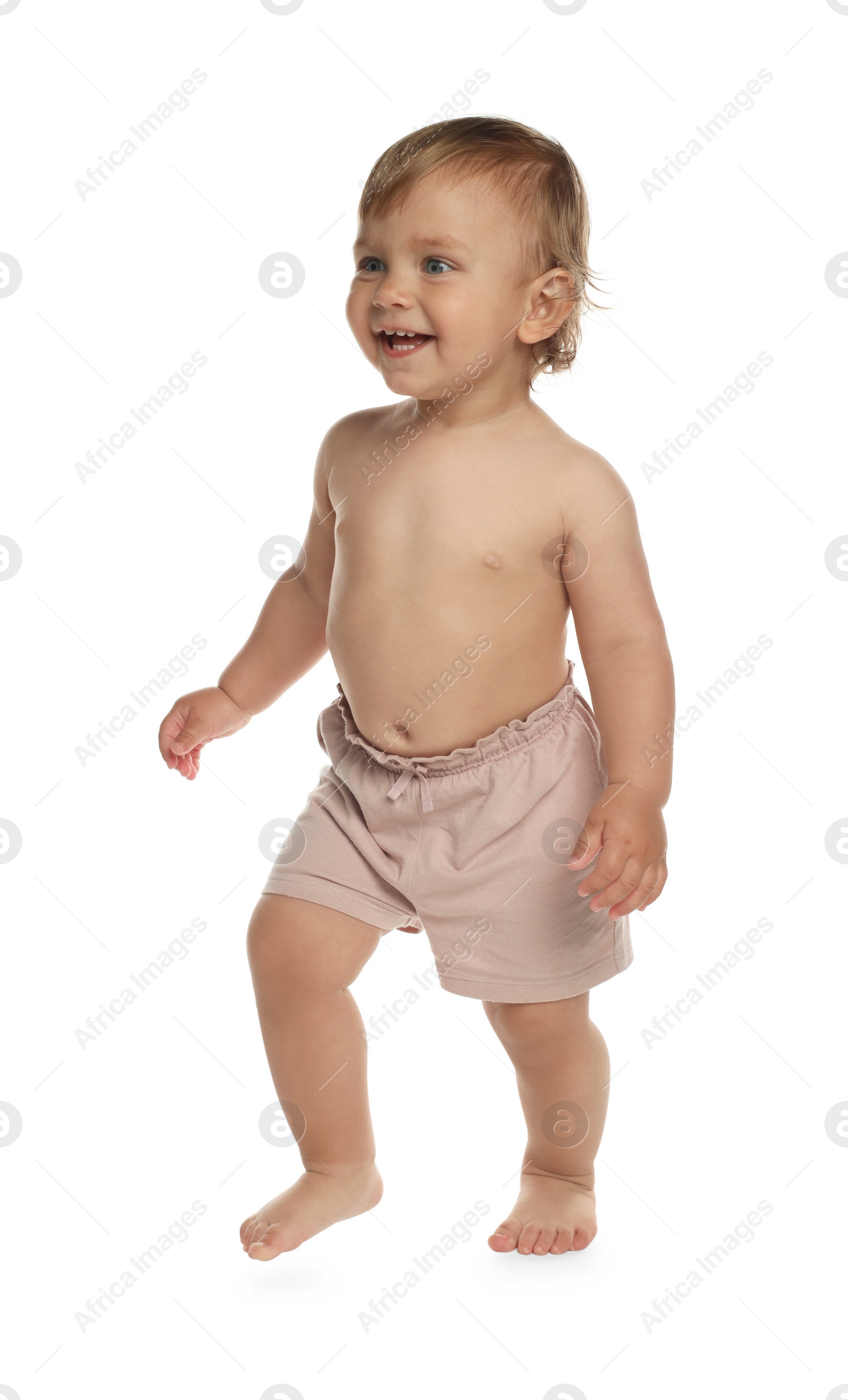 Photo of Cute baby in shorts learning to walk on white background