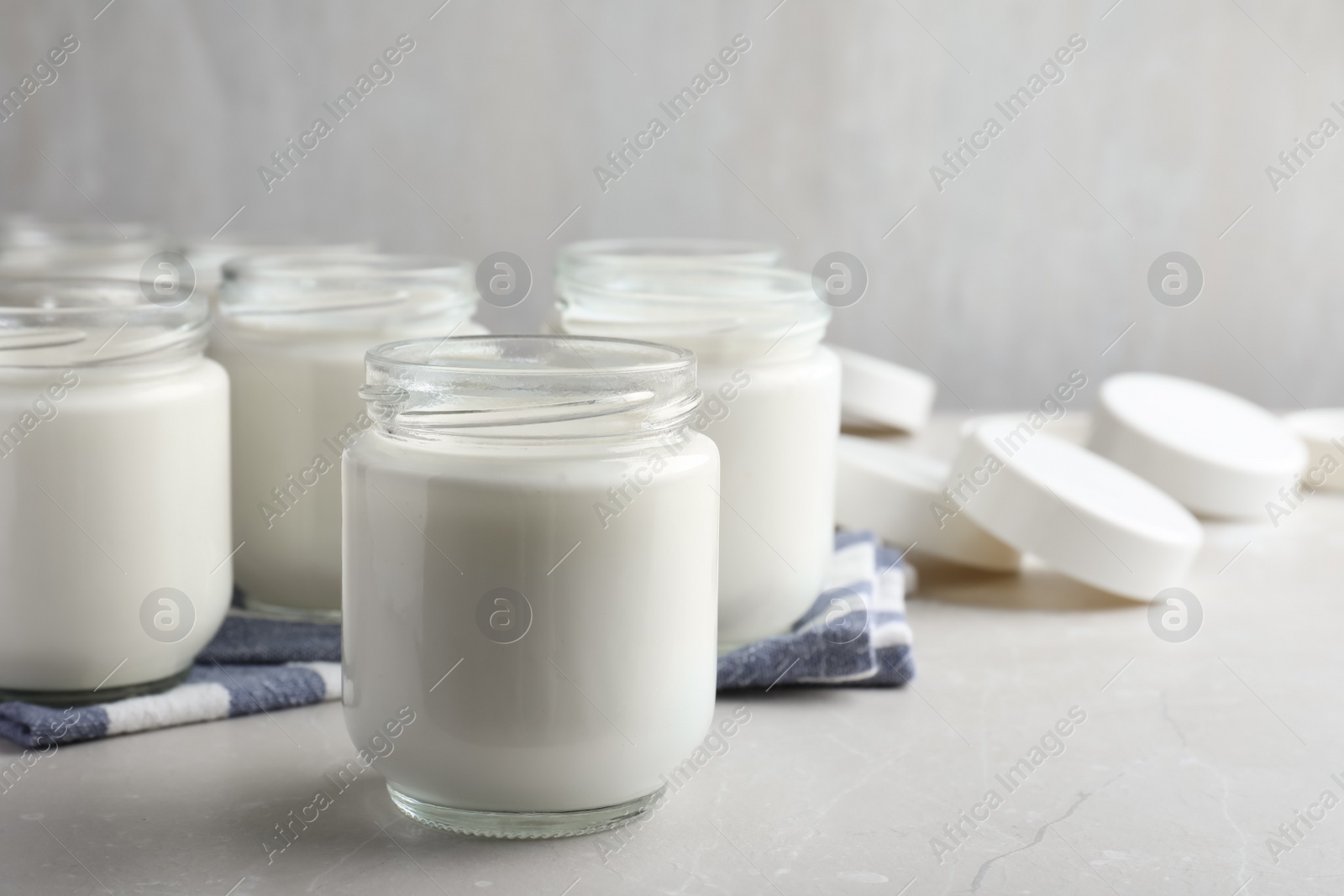 Photo of Tasty yogurt on light grey marble table