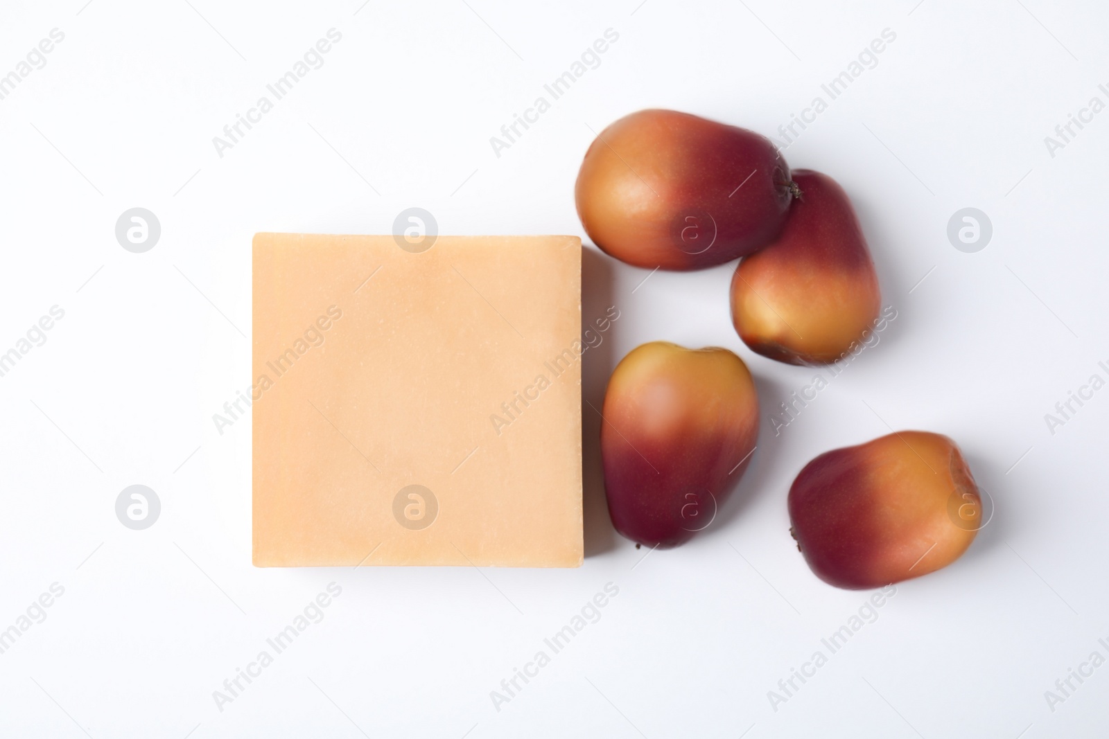 Image of Fresh ripe palm oil fruits and soap bar on white background, top view