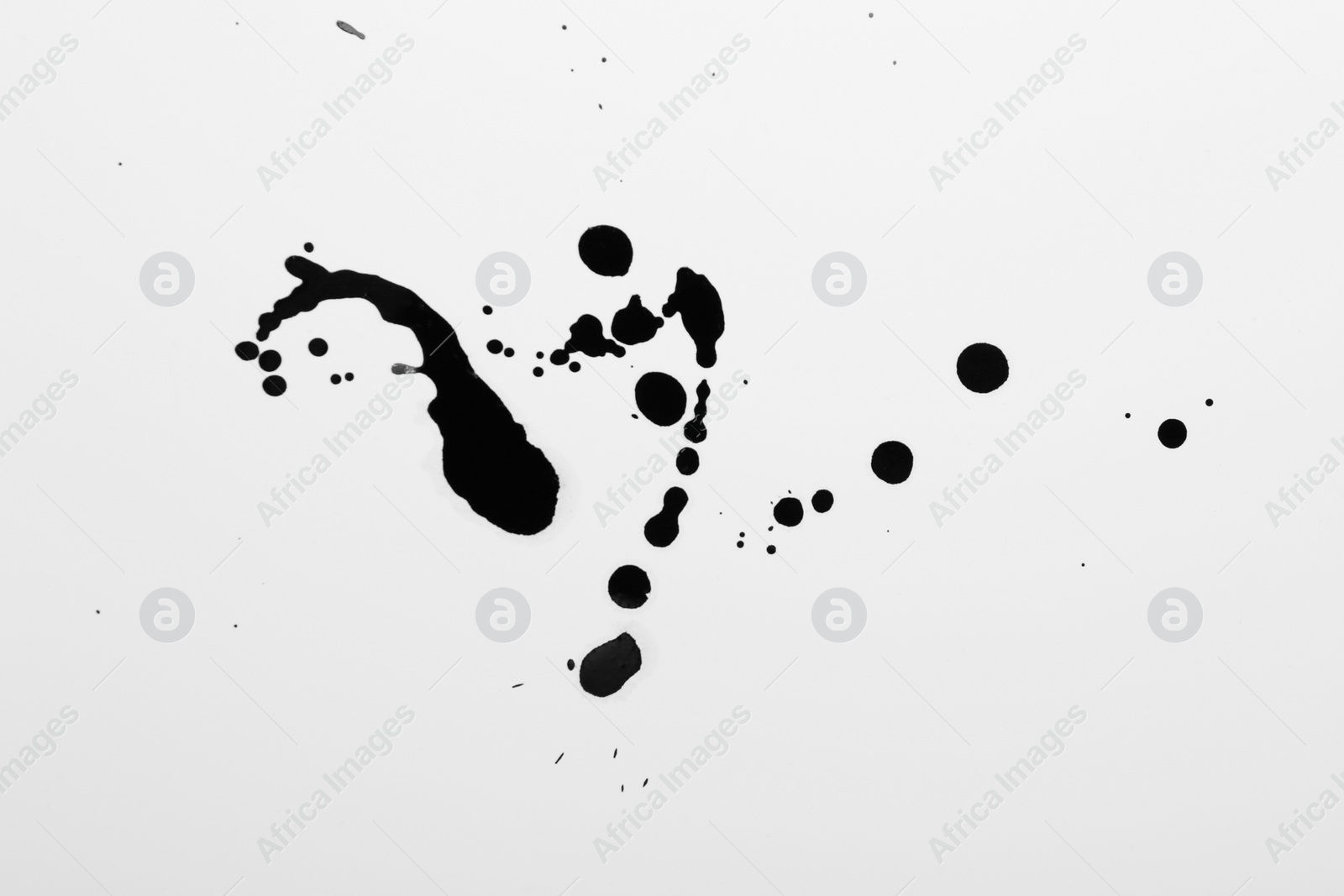 Photo of Blots of black ink on white background, top view