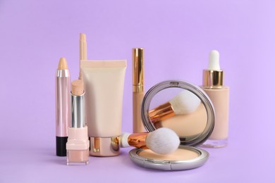 Photo of Foundation makeup products on violet background. Decorative cosmetics