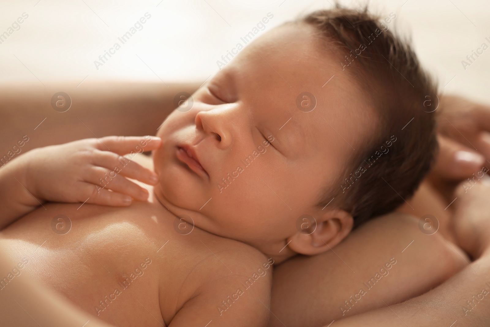 Photo of Woman holding her sleeping newborn baby, closeup