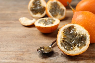 Photo of Delicious ripe granadillas on wooden table, closeup. Space for text