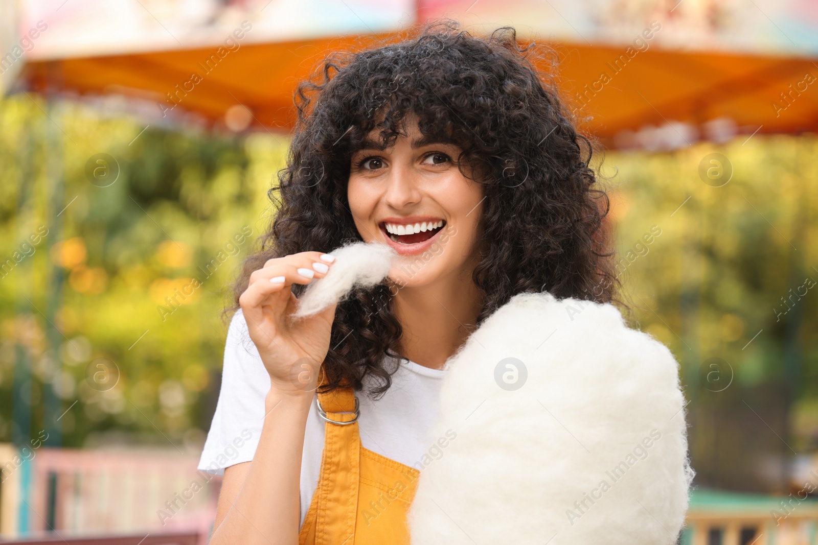 Photo of Beautiful woman eating cotton candy in park