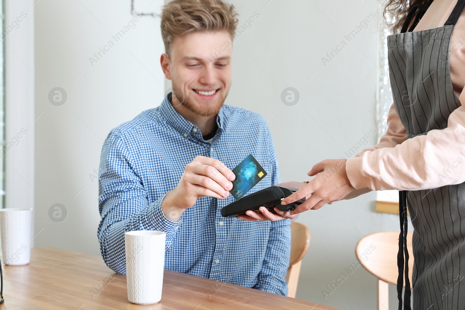 Photo of Client using credit card machine for non cash payment in cafe