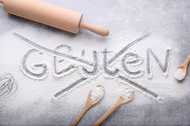 Photo of Crossed out word Gluten and different kitchen utensils on grey background, flat lay