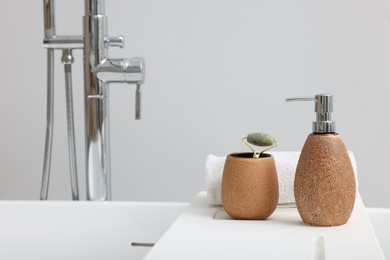 Photo of Different personal care products and accessories on bath tub in bathroom, space for text