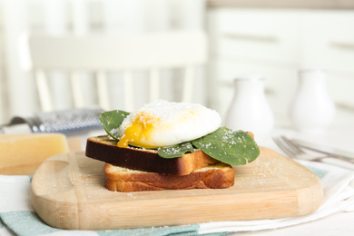 Delicious poached egg with toasted bread and spinach served on wooden board