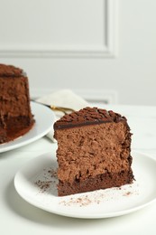 Photo of Piece of delicious chocolate truffle cake on white table
