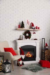 Beautiful Christmas themed photo zone with armchair and fireplace in room
