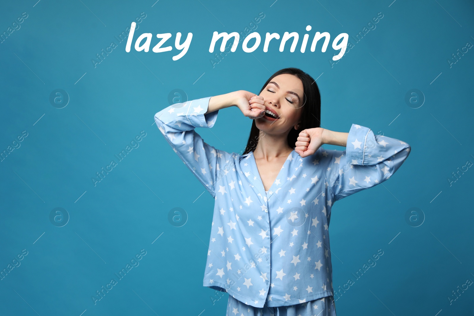 Image of Beautiful Asian woman in pajamas stretching on blue background. Lazy morning