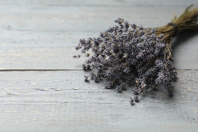 Dried lavender flowers on grey wooden table, closeup. Space for text