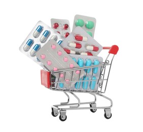 Photo of Blisters with different pills in mini shopping cart on white background