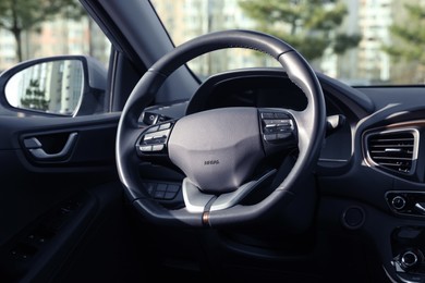 Photo of Black steering wheel inside of modern car