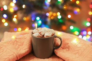 Photo of Cup of delicious hot cocoa with marshmallows on light cloth
