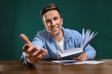 Portrait of male teacher working at table in classroom