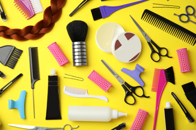 Professional tools for hair dyeing on yellow background, flat lay