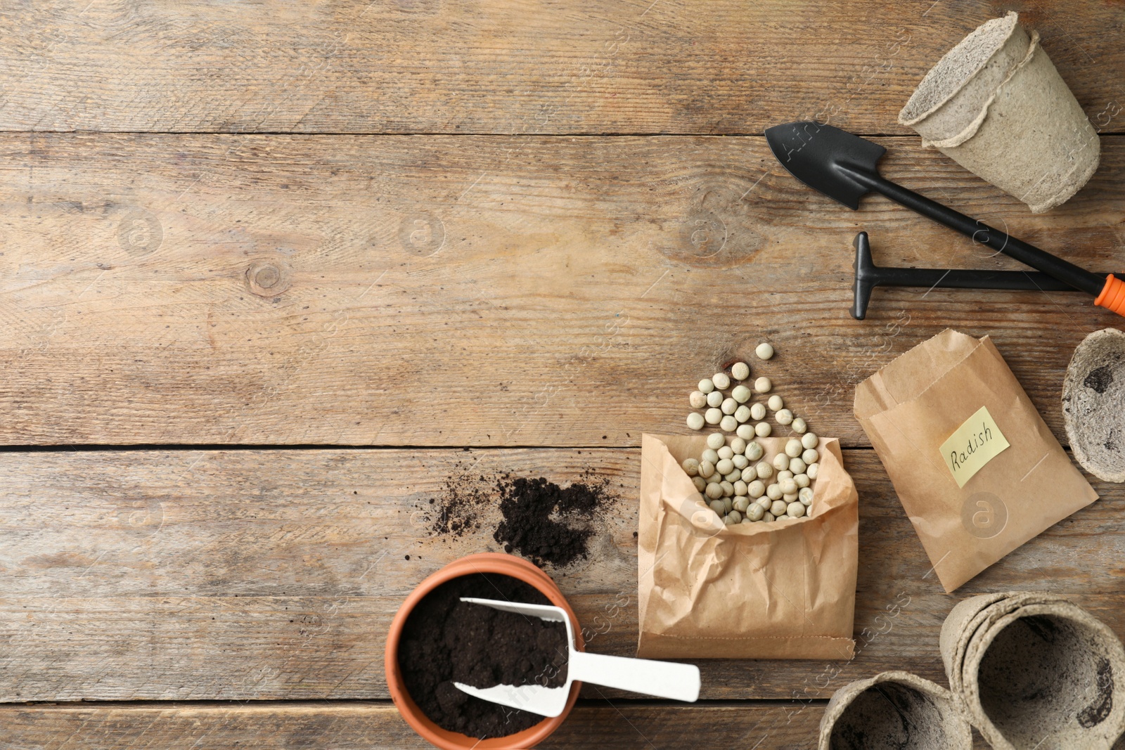 Photo of Flat lay composition with vegetable seeds and gardening equipment on wooden table. Space for text