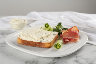 Delicious sandwich with cream cheese, cucumber and jamon on white marble table