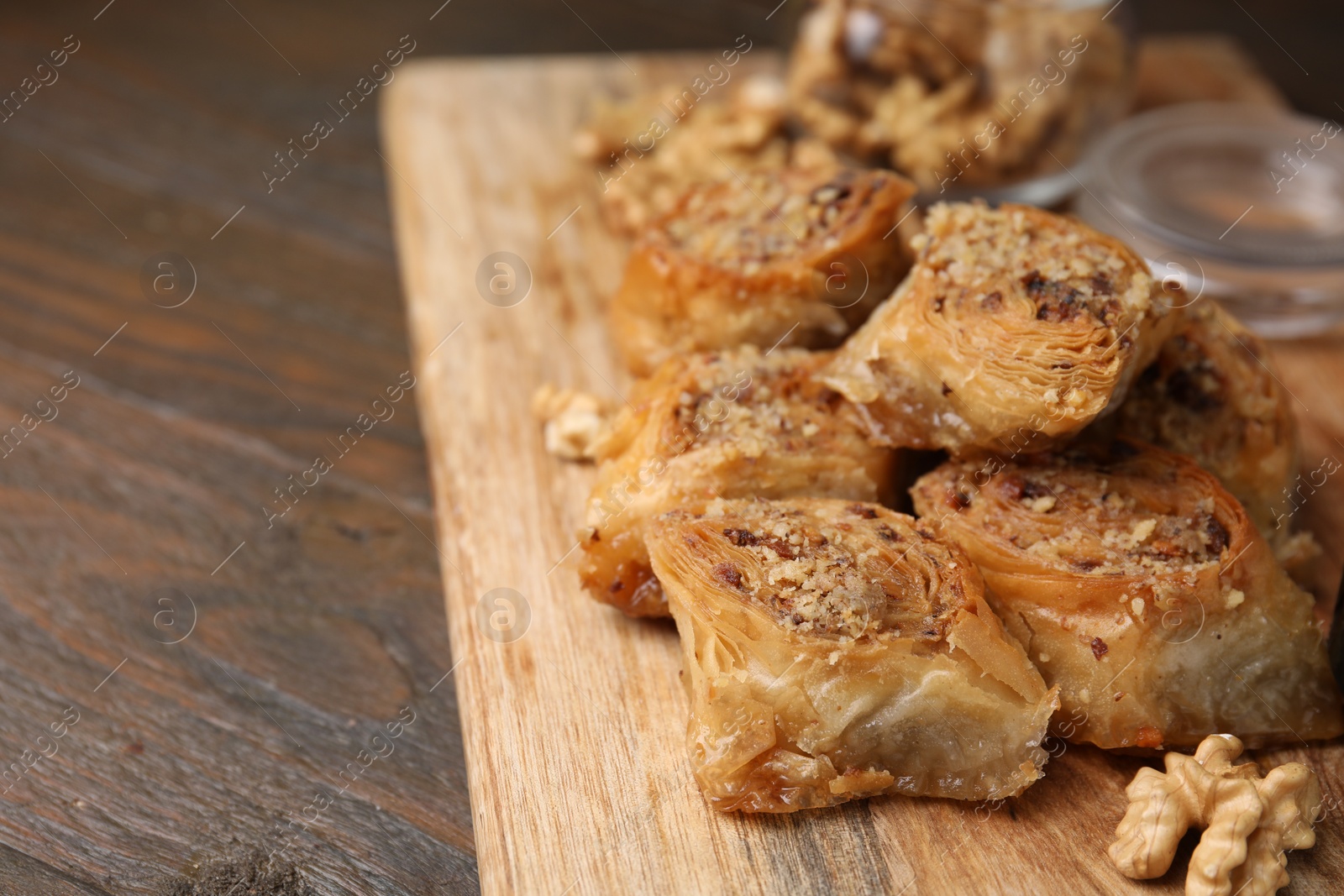 Photo of Eastern sweets. Pieces of tasty baklava on wooden table, closeup. Space for text