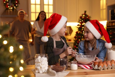 Photo of Cute little children making dough for delicious Christmas cookies at home