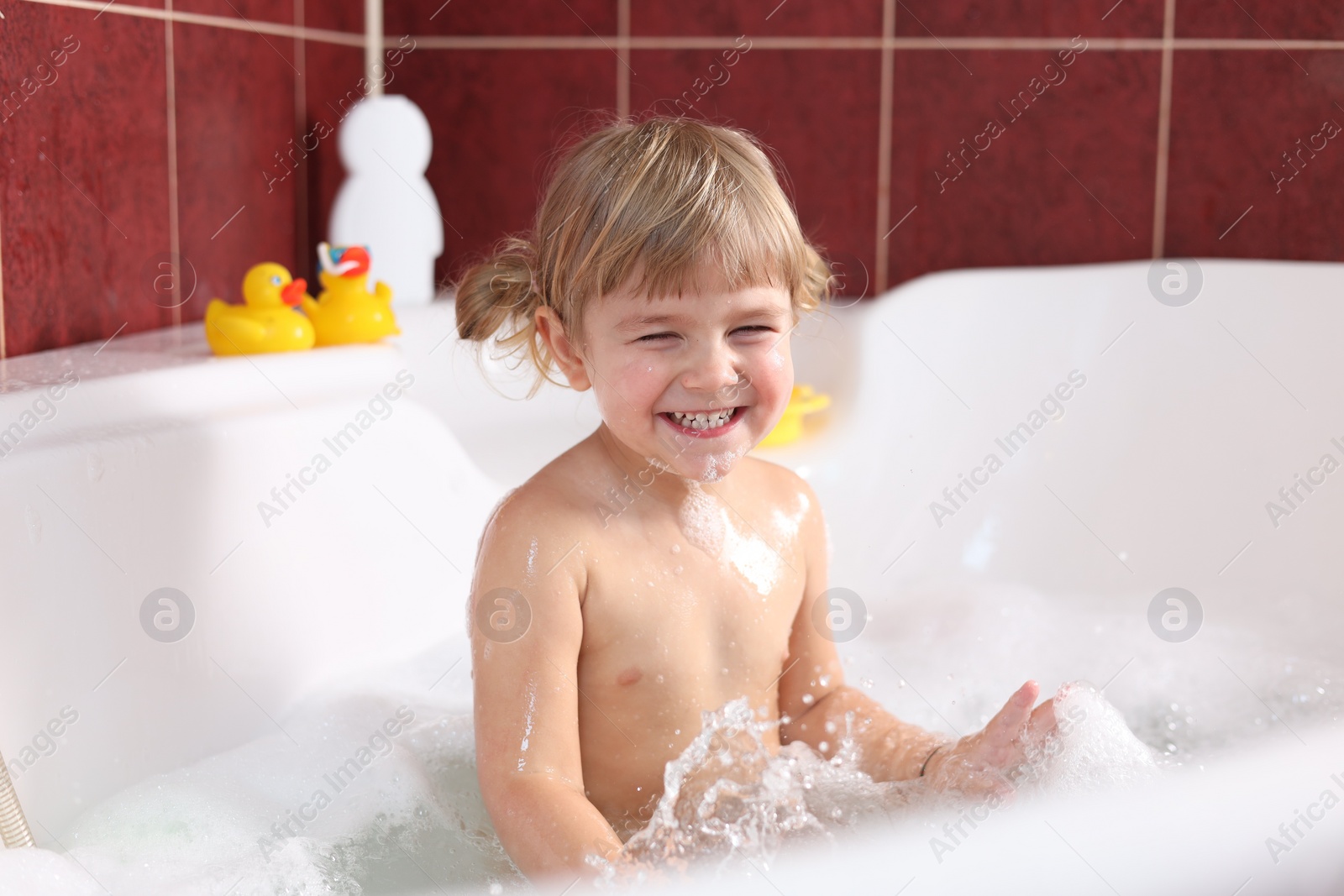 Photo of Happy girl having fun in bathtub at home