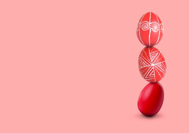 Image of Stack of bright Easter eggs on pink background, space for text