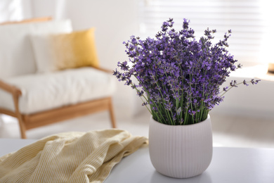 Beautiful lavender flowers and yellow shirt on white table indoors. Space for text