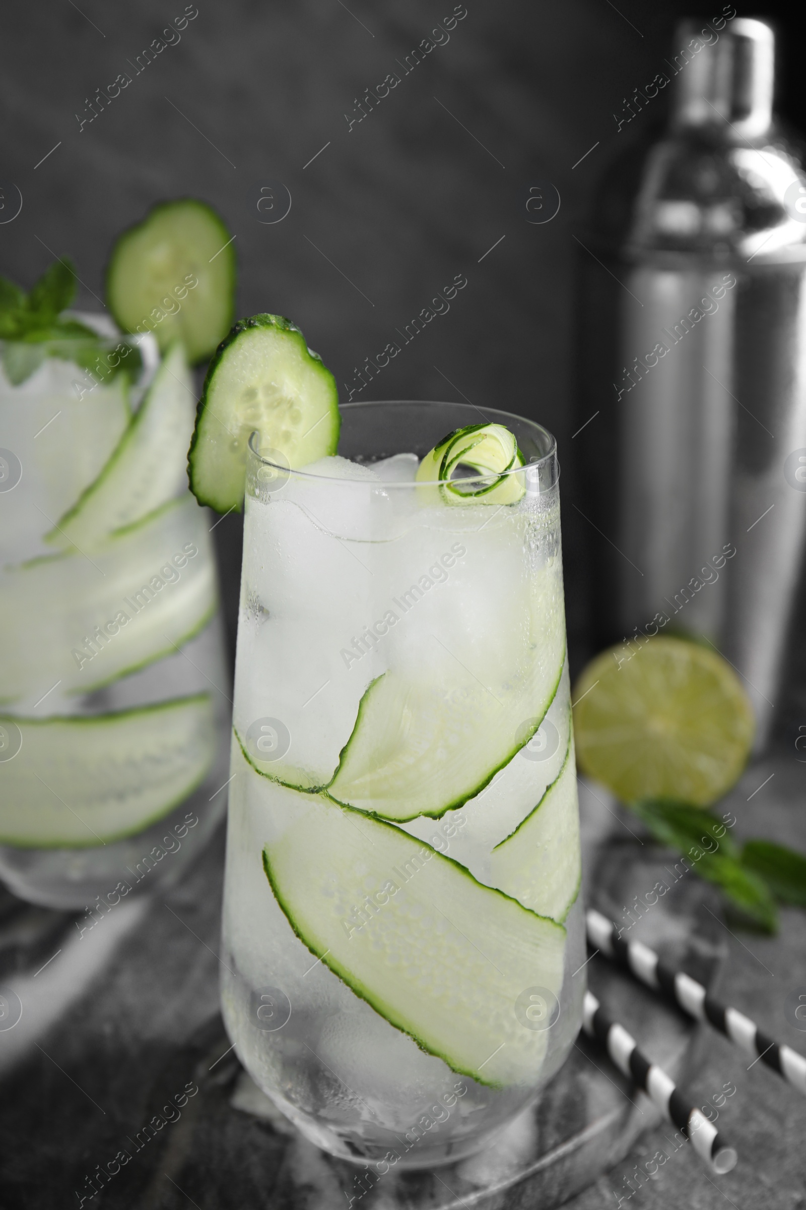 Photo of Refreshing cucumber water with mint on dark grey table, closeup