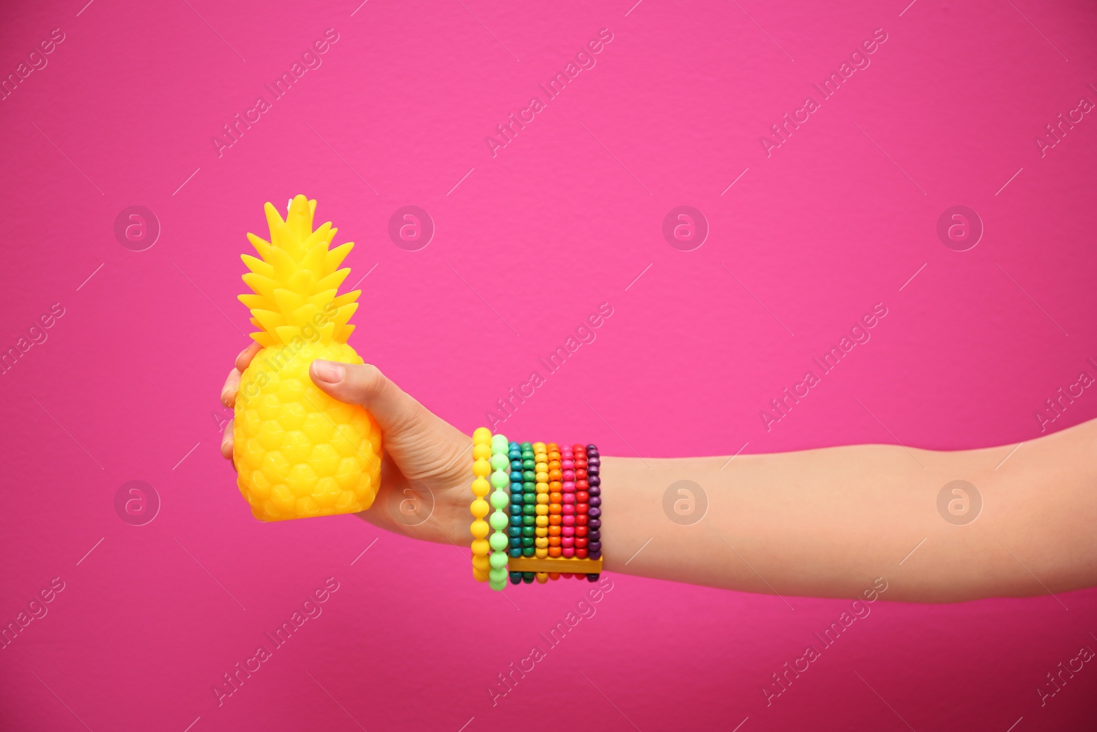 Photo of Woman holding stylish pineapple candle on color background