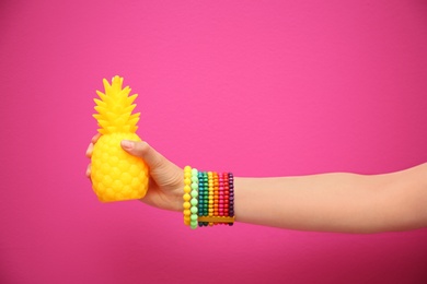 Photo of Woman holding stylish pineapple candle on color background