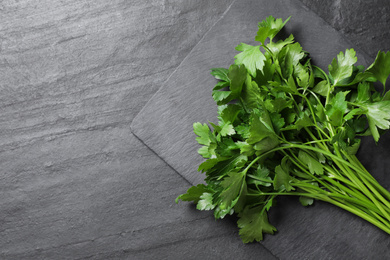 Bunch of fresh green parsley on grey table, top view. Space for text